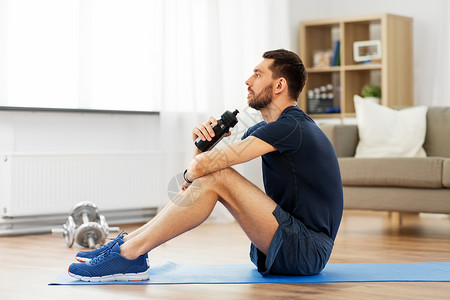 运动,健身健康的生活方式男人家里训练时瓶子里喝水男人家里训练时喝水图片