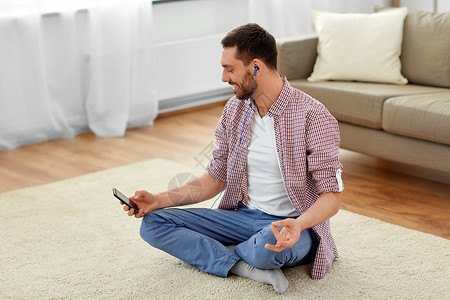 技术,冥想放松人耳机听音乐智能手机冥想莲花姿势家里戴耳机的人听音乐冥想图片