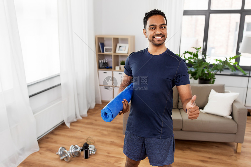运动健康的生活方式微笑的印度男子与健身跟踪拇指家里印度男子与健身跟踪竖大拇指图片