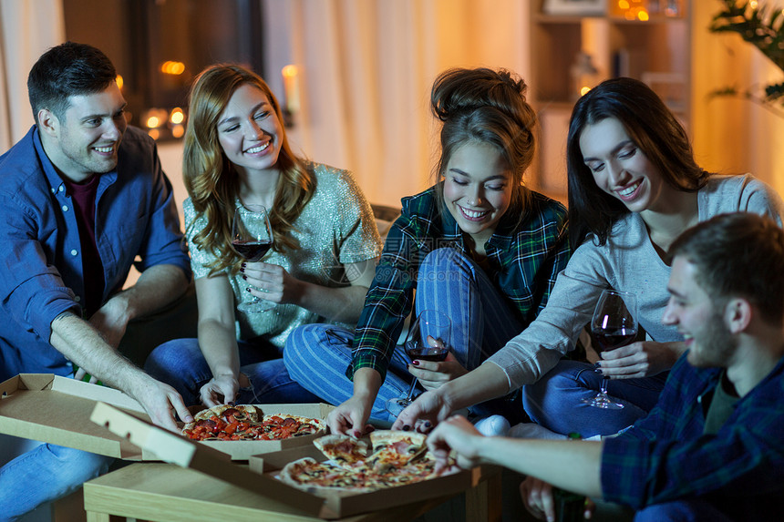 友谊食物休闲快乐的朋友晚上家吃比萨饼喝含酒精的酒朋友家吃披萨喝葡萄酒图片