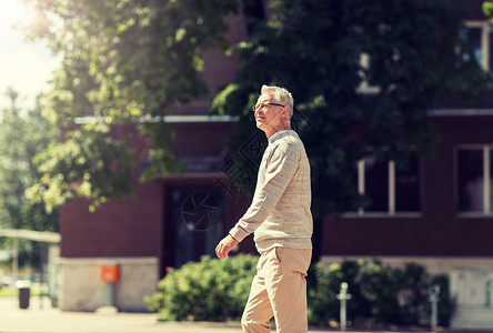 休闲人的老人走夏季城市街道老人沿着夏城街走图片
