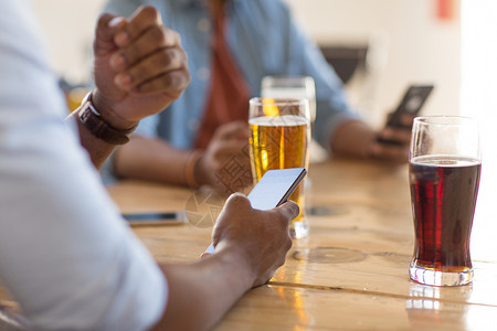 人技术智能手机的人酒吧酒吧喝啤酒阅读信息智能手机的男人酒吧酒吧喝啤酒图片