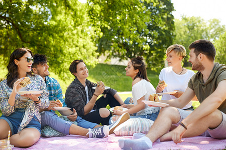 食物友谊友谊休闲快餐群快乐的朋友夏天公园野餐时吃三明治汉堡快乐的朋友夏天野餐时吃三明治背景