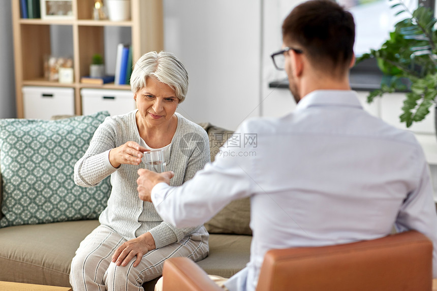 老心理学,心理治疗老心理学家心理治疗会议上给悲伤的老妇女客户喝杯水心理学家给老妇女喝杯水图片