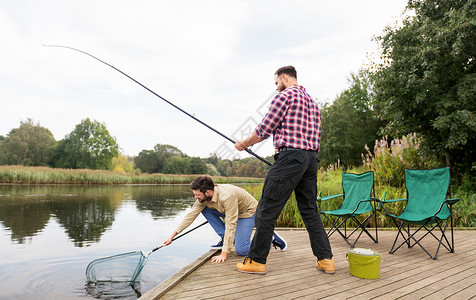 休闲人的男朋友与网钓鱼杆湖墩湖边网钓鱼竿的男朋友背景图片