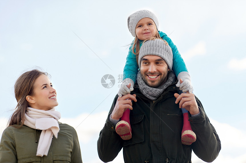 家庭休闲人的快乐的母亲父亲背着小女儿秋天散步快乐的家庭秋天散步图片