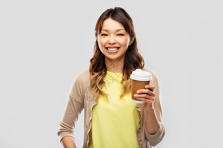 人饮料的快乐的轻亚洲妇女喝外卖咖啡纸杯灰色背景快乐的亚洲女人喝咖啡图片