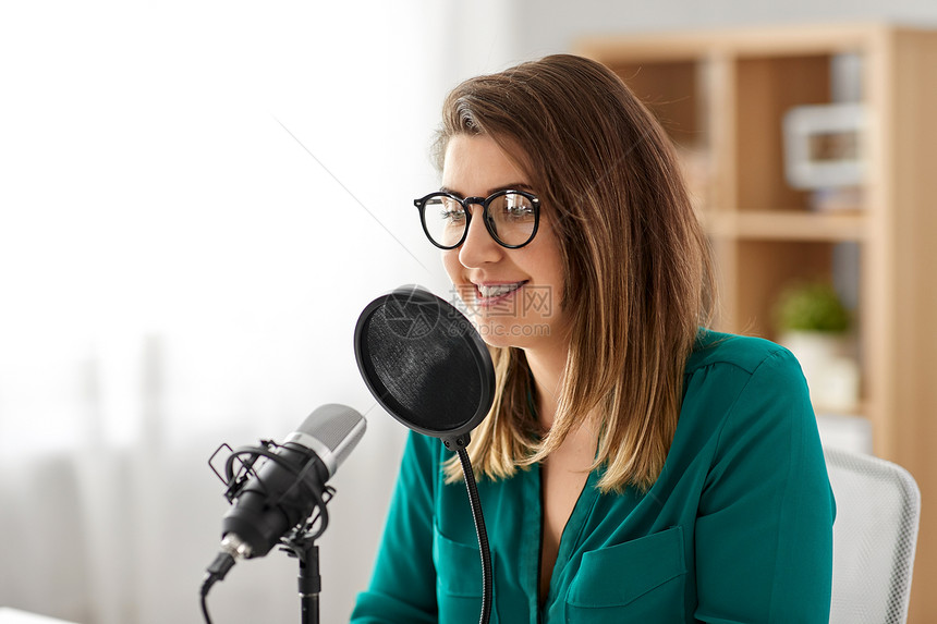技术,大众媒体人们的戴着麦克风的眼镜的女人录音室交谈录制播客演播室里麦克风录音播客的女人图片