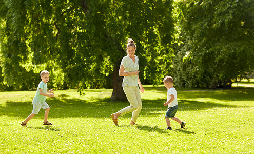 家庭休闲人的快乐的母亲两个小儿子夏季公园跑步玩接球游戏妈妈儿子夏天公园玩接球游戏背景图片