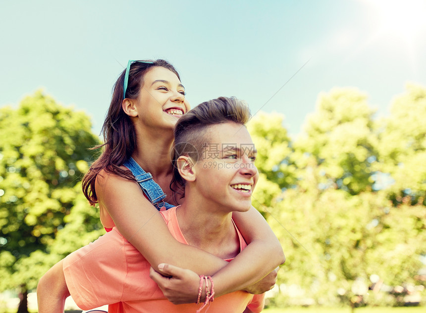 假期,爱人的快乐的微笑青少夫妇夏季公园玩得开心快乐的十几岁的夫妇夏天的公园玩得很开心图片