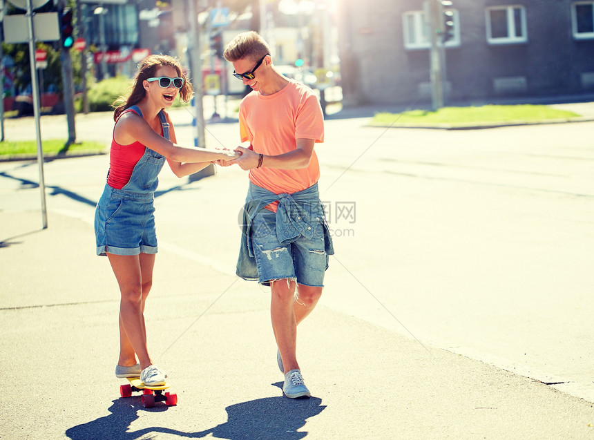 暑假,极限运动人们的快乐的十几岁的夫妇骑着短的现代巡洋舰滑板城市街道轻夫妇城市街道上骑滑板图片