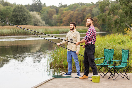 休闲人的男朋友与钓鱼竿湖墩湖墩上钓竿的男朋友背景图片