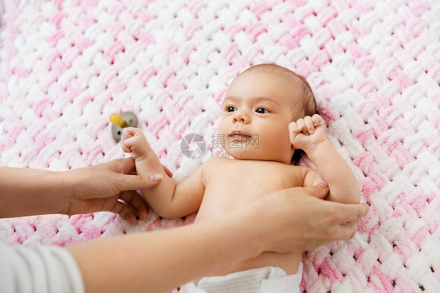 婴儿期,母亲人的母亲的手可爱的小女儿躺针的粉红色毛毯的毛绒纱可爱的女婴躺针毛绒毯上图片