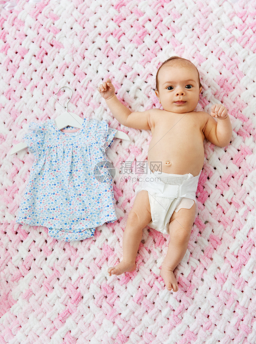 婴儿期,衣服人的甜蜜的小女孩穿着尿布躺针粉红色毛毯的毛绒纱穿着尿布的女婴躺毯子上,穿着衣服图片