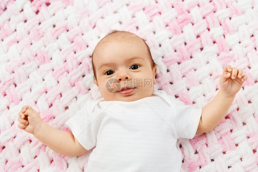 婴儿期人们的甜蜜的小女孩躺针粉红毛毯的毛绒纱可爱的女婴躺针毛绒毯上图片