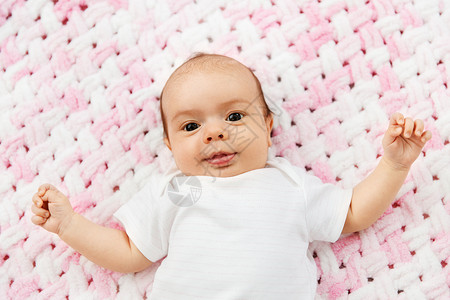 婴儿期人们的甜蜜的小女孩躺针粉红毛毯的毛绒纱可爱的女婴躺针毛绒毯上背景图片