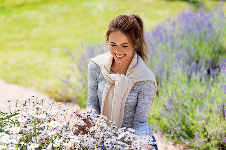 园艺人们的快乐的轻妇女与洋甘菊花夏季花园夏天花园里带花的轻女人背景图片