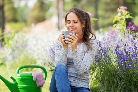 园艺人们的轻妇女夏季花园喝茶咖啡夏天花园里喝茶咖啡的女人背景图片