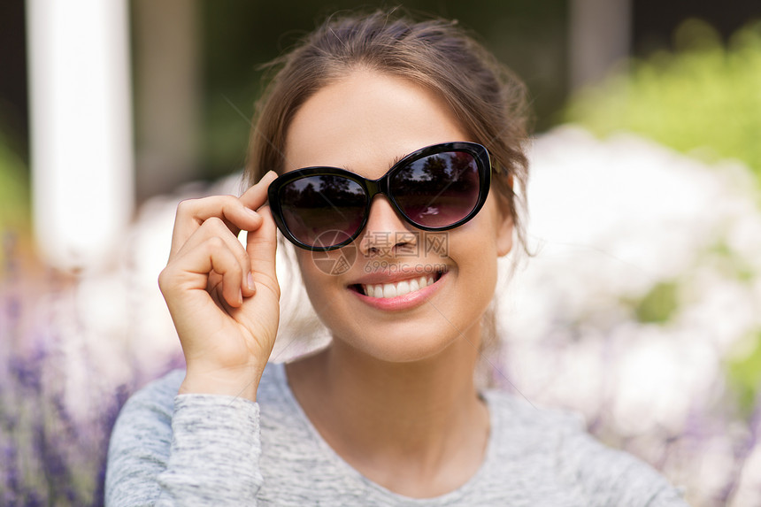 夏季,休闲人们的快乐的轻女人夏季花园戴太阳镜的肖像夏天花园里戴太阳镜的快乐轻女人图片