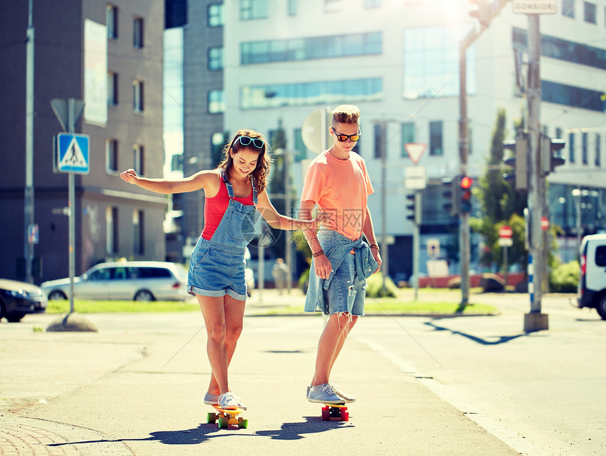 暑假,极限运动人们的快乐的青少夫妇骑着短的现代巡洋舰滑板城市街道轻夫妇城市街道上骑滑板图片