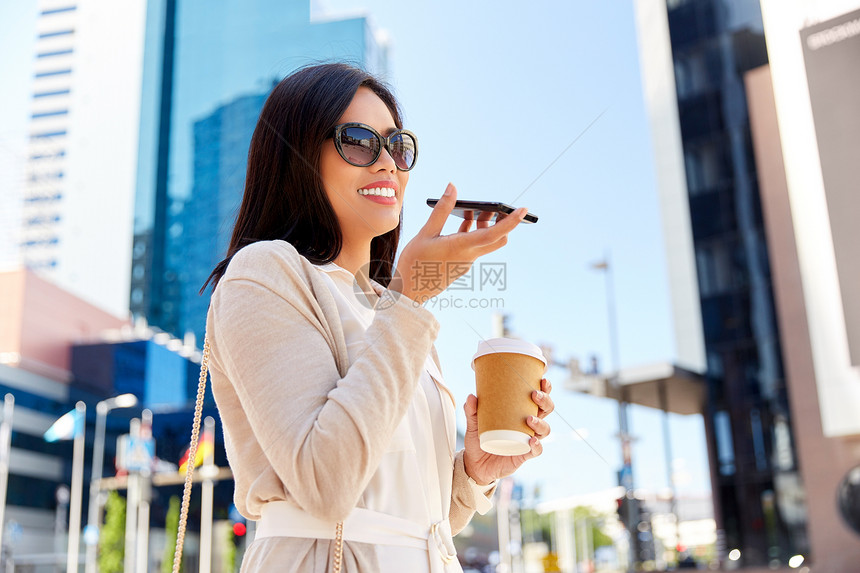 沟通,生活方式技术快乐微笑的轻亚洲妇女戴着太阳镜,带着外卖咖啡杯,智能手机城市街道上录制语音信息城市里的女人图片