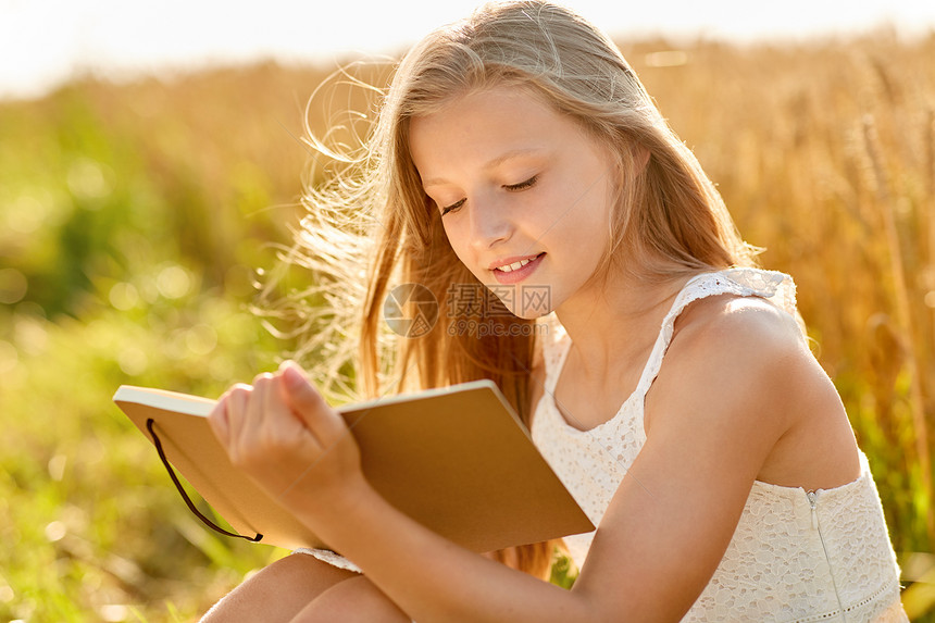 乡村,文学休闲微笑的轻女孩穿着白色连衣裙写日记绘画素描夏天的谷物领域微笑的女孩谷物地里写日记图片