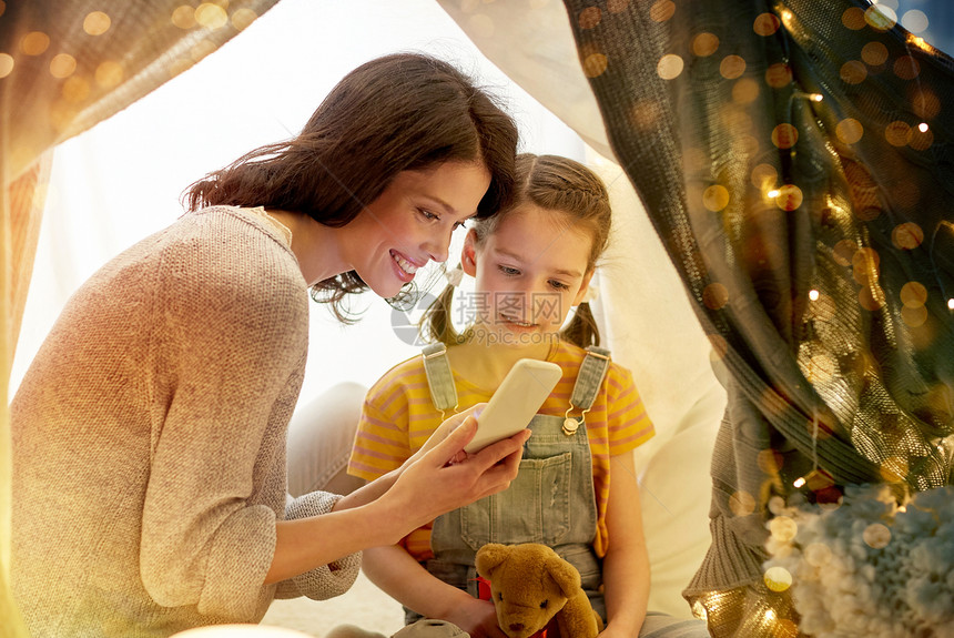 家庭,技术快乐的母亲小女儿与智能手机孩子们的帐篷晚上家家庭幸福,智能手机孩子们的帐篷里图片