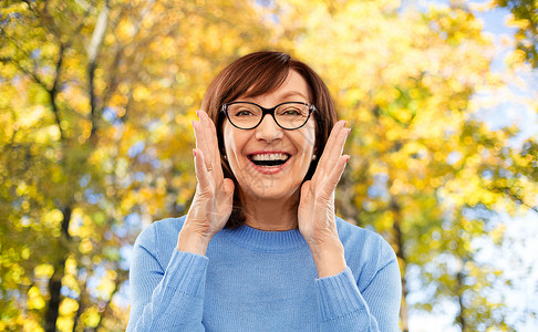 微笑的老年女子戴着眼镜秋天的公园图片