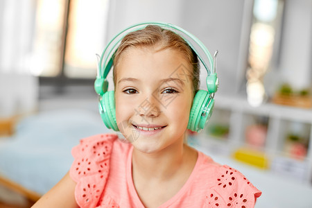 儿童技术微笑女孩耳机听音乐家的肖像戴耳机的女孩家听音乐图片