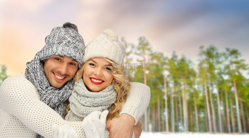 冬天,诞节人们的幸福的戴着帽子围巾拥抱森林背景上夫妇拥抱冬天的森林背景上图片