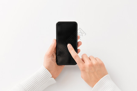 小工具技术与黑色智能手机亲密的手用黑色智能手机闭上双手图片