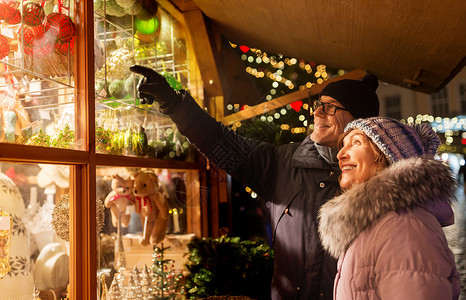 购物,寒假人们的快乐的老夫妇诞市场纪念品商店窗口市政厅广场塔林,爱沙尼亚快乐的老夫妇诞市场拥抱背景图片