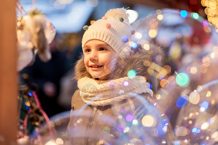 假期,童人的快乐的小女孩诞市场冬季晚上冬天诞节市场上快乐的小女孩背景图片