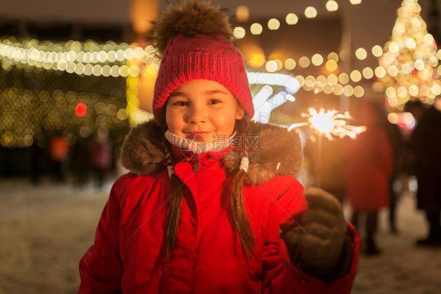 假期,童人的快乐的小女孩与火花诞市场冬季晚上快乐的女孩与火花诞节市场图片
