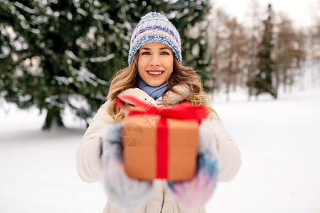 诞节,假日休闲快乐的轻妇女与礼品盒户外冬季快乐的轻女人冬天送诞礼物图片