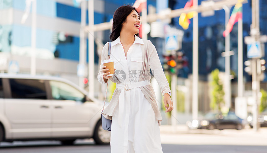 生活方式人们的快乐微笑的轻亚洲妇女带着外卖咖啡杯走城市街道上微笑的女人带着外卖咖啡杯城市图片