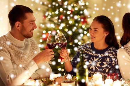 寒假人们的快乐的夫妇家里庆祝诞节,雪上喝红酒幸福的夫妇家里庆祝诞节图片