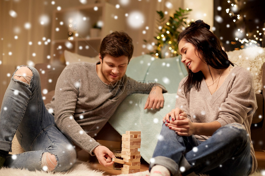 诞节,休闲人们的快乐的夫妇家里玩积木游戏雪地上快乐的夫妇家里玩积木游戏图片