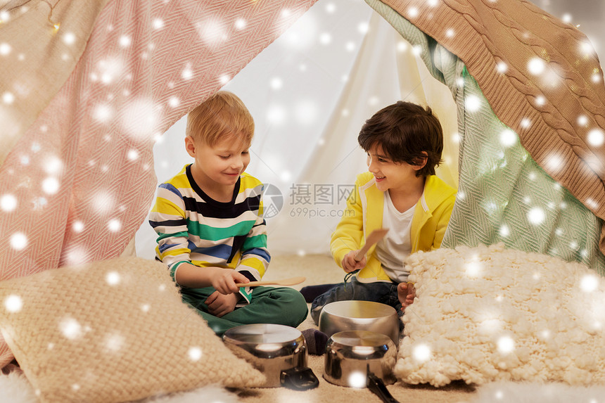童诞节的快乐的小男孩用炊具孩子们的帐篷里玩音乐,雪地上孩子们家里的帐篷里着罐子放音乐图片