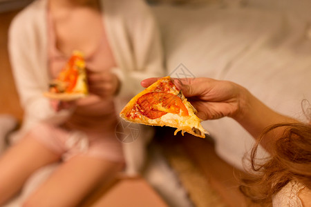 穿着睡衣的闺蜜家吃披萨背景图片