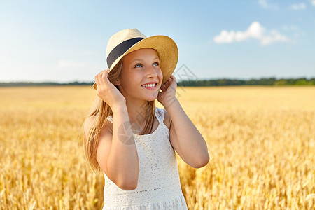 夏天麦田里上戴草帽的女孩的肖像图片