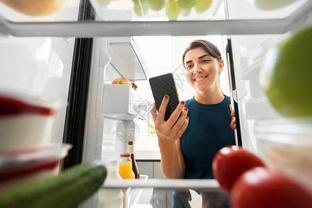 手机列表素材女人着手机冰箱前背景