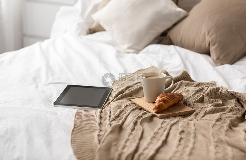 舒适,内部平板电脑,杯咖啡牛角包床上舒适的家平板电脑,咖啡杯牛角包家里的床上图片