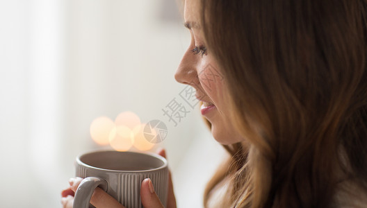 饮料,诞节潮湿的快乐的女人与灯光杯咖啡茶家里家喝杯咖啡的快乐女人图片