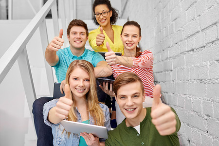 美国高中生教育技术学理念群快乐的国际高中生同学,平板电脑电脑坐楼梯上平板电脑的高中生背景