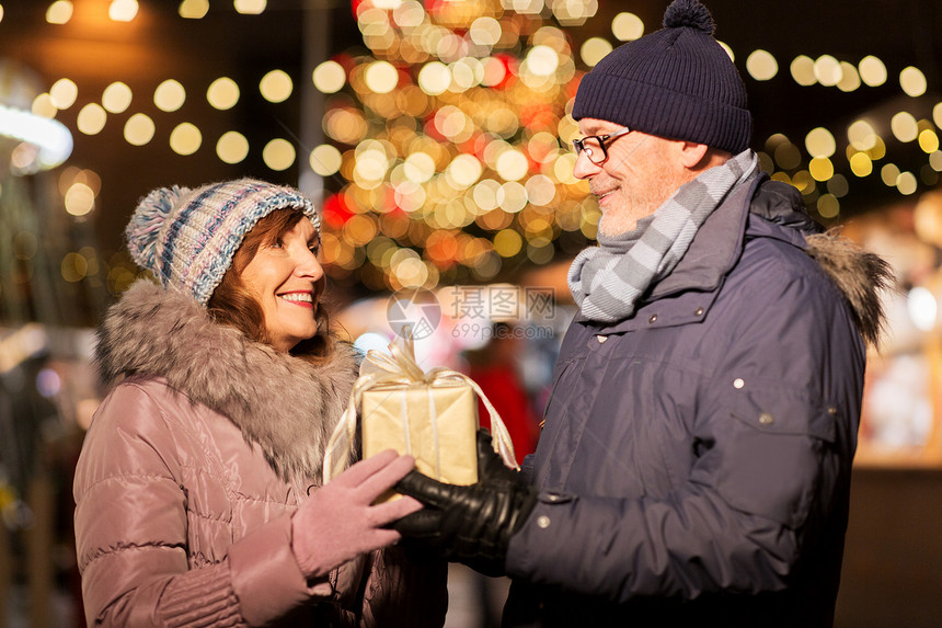 爱,寒假人的快乐的老夫妇诞市场上的市政厅广场塔林,爱沙尼亚快乐的老夫妇诞节市场带着礼物图片