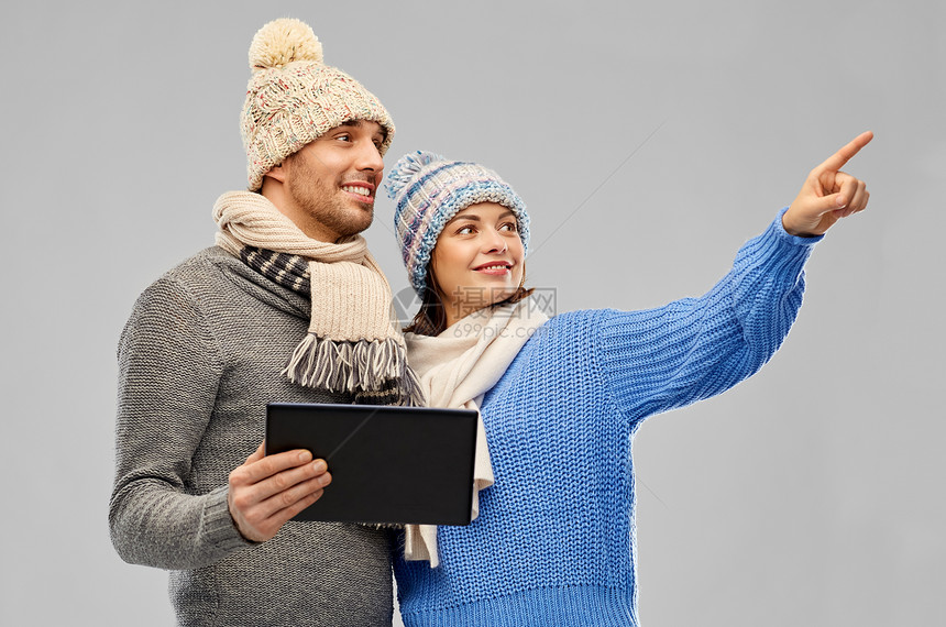 技术,诞节冬季服装幸福夫妇针帽围巾与平板电脑灰色背景穿着冬天的衣服平板电脑图片