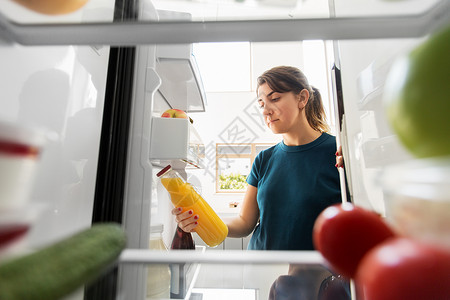 健康饮食,食物饮食妇女冰箱家里厨房瓶橙汁女人家里冰箱里瓶果汁图片