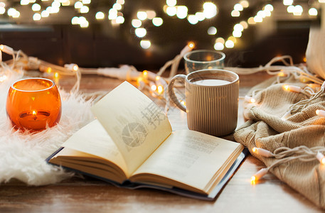 热灯潮湿舒适的家庭书,咖啡热巧克力蜡烛与花环窗台上窗台上的书咖啡热巧克力背景
