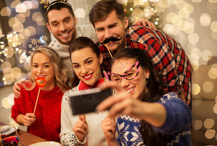 节日庆祝快乐的朋友与派道具自拍智能手机家里诞晚餐朋友们诞晚餐上自拍图片